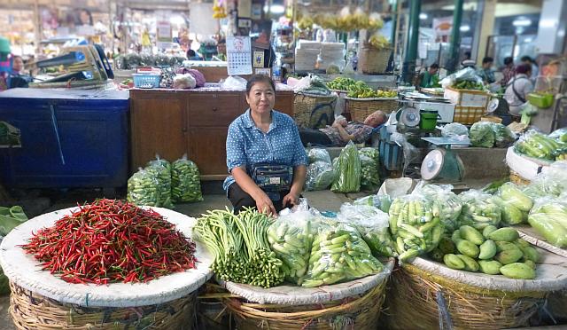 vendeuse devant ses légumes.